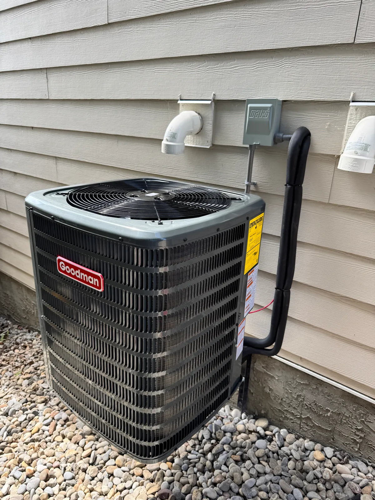 Goodman AC condenser unit professionally installed outside a Calgary home by Wagner Mechanical